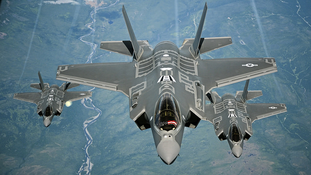 Three F-35A Lightning fighter aircraft flying over land