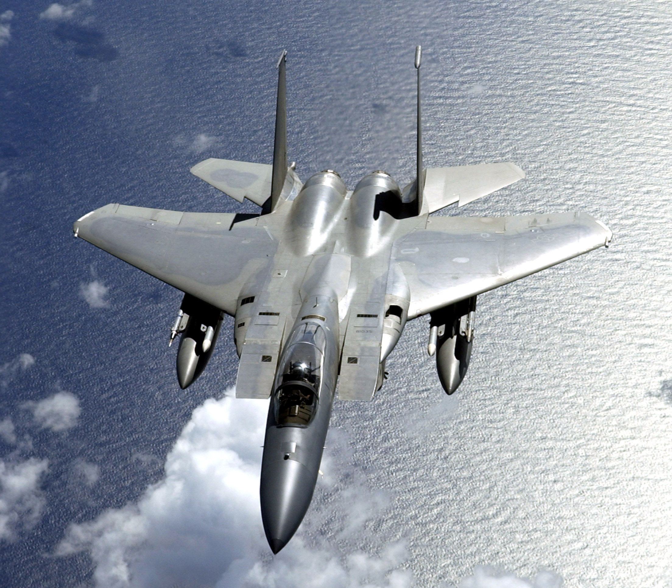 A F-15 Eagle fighter flying over water