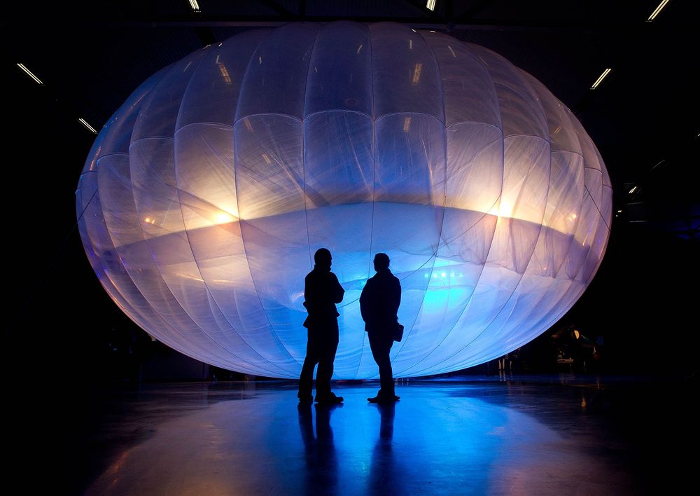 two people standing in front of a glowing balloon