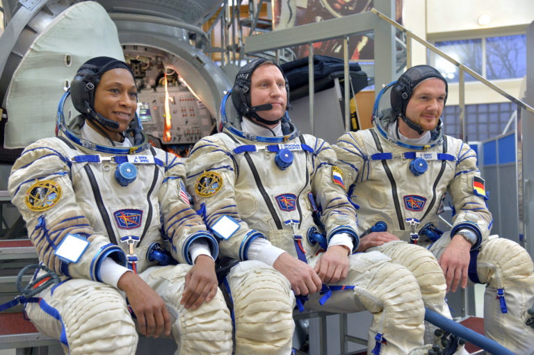 three astronauts in full gear sitting down