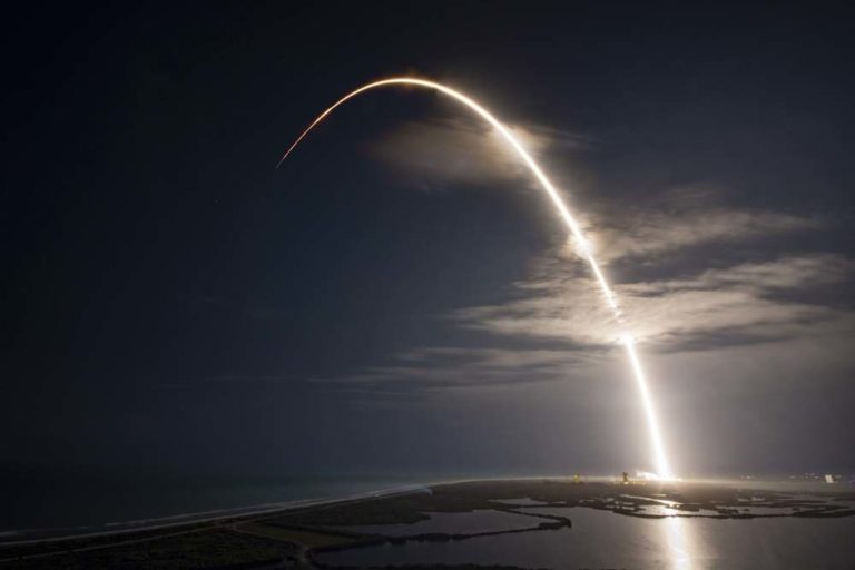 SpaceX rocket launching in an arc at night (future of the space force)